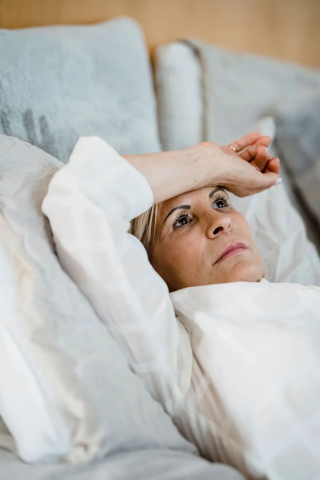 Woman in her forties resting in bed, dealing with perimenopause night sweats